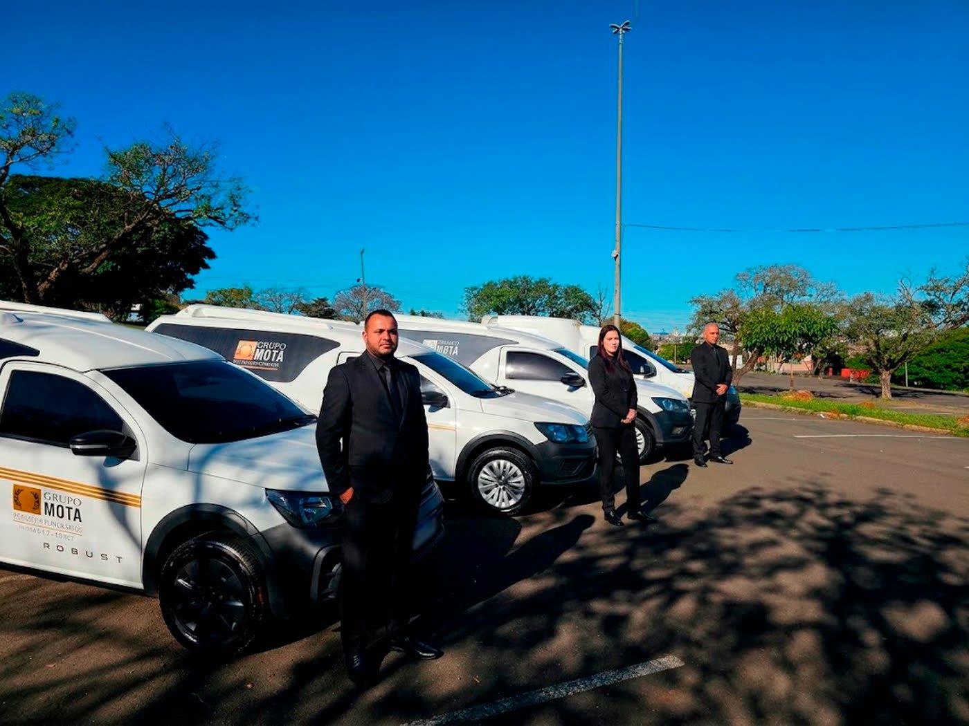 Equipe do Grupo Mota ao lado da frota própria identificada